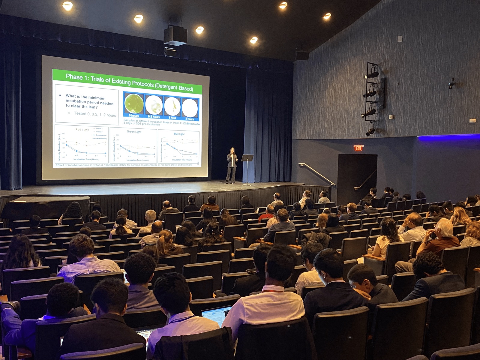 Student presenting research to a full auditorium